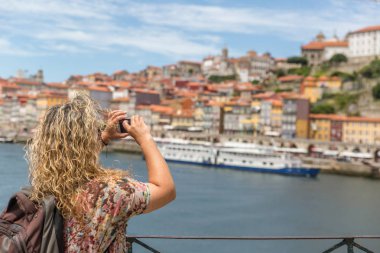 Sırtında sırt çantası olan sarışın bir turist kadın, bir pictu alır