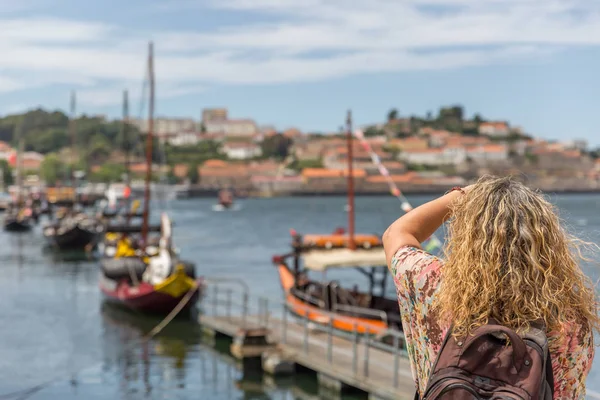 Bir turist şehirde ünlü rabelos teknelerin bir fotoğraf çeker 