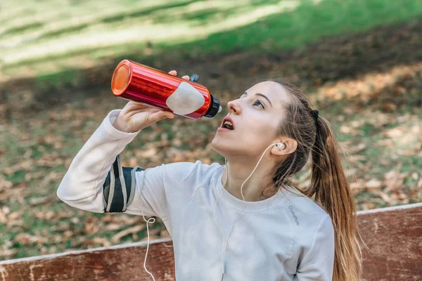 Chica Rubia Delgada Bebe Agua Una Botella Roja Mientras Está — Foto de Stock
