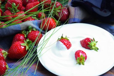 Çilek ve krema bir rustik tarzda kareli kumaş üzerinde.