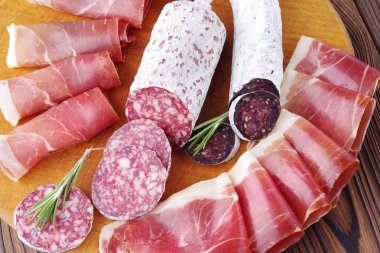 Yakın çekim et lezzetleri, İtalyan sosisi ahşap oyun tahtası ve jamon ince dilimler.