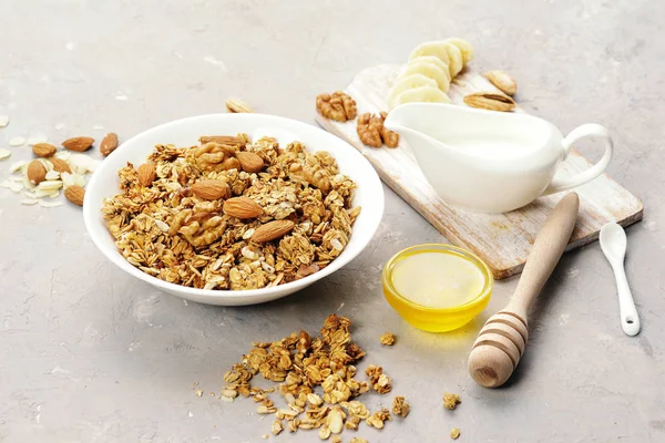 Granola with nuts and milk on a bright table.