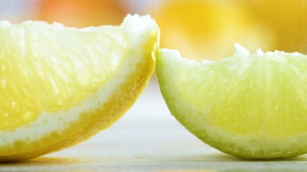 Macro 4k images de pluie tombant sur des tranches de citron, de citron vert et d'orange sur une table en bois blanc — Video