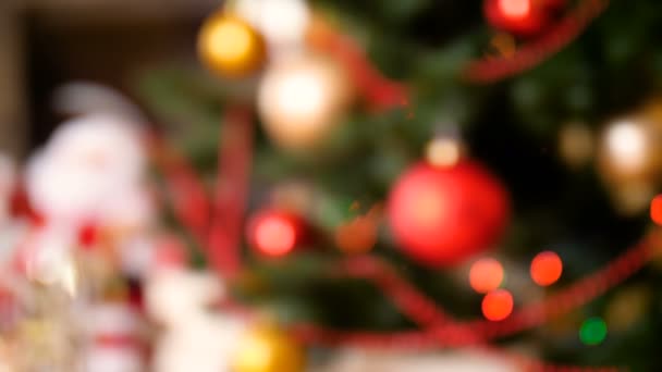 Fuera de foco 4k metraje de hermoso árbol de Navidad decorado con adornos y luces de colores en la sala de estar — Vídeo de stock