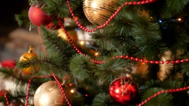 Paning 4k beelden van de camera beweegt langs mooi gedecoreerde kerstboom met kleurrijke babubles en verlichting — Stockvideo