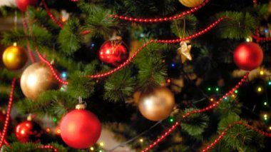 Kırmızı ve altın baublbes ve renkli loghts ile güzel Noel ağacı üzerinde kamera defocusing, Closeup 4 k görüntüleri