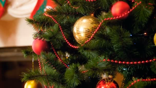Closeup 4k záběry z kamery směrem k zdobené vánoční strom na obývací pokoj s krbem — Stock video