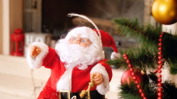 4 k-video av Santa Claus figur anseende under julgran dekorerad med färgglada lampor på vardagsrum — Stockvideo