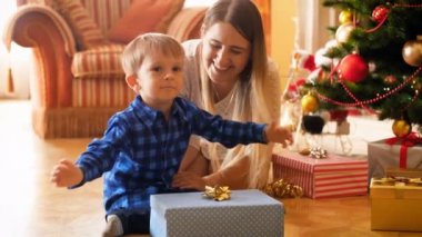 çok güzel anne Noel ağacının altında ile sabah oturan yürümeye başlayan çocuk boy gülümseyerek 4 k görüntüleri