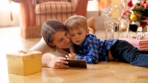 Happy Mother Lying Florr Her Little Son Christmas Using Smart — Stock Video