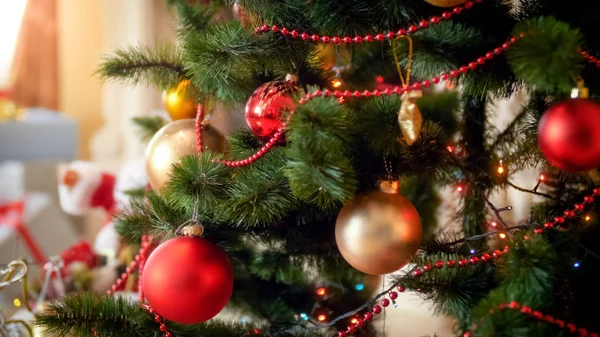 Imagen de primer plano de luces de colores y adornos colgando en el árbol de Navidad en la sala de estar — Foto de Stock