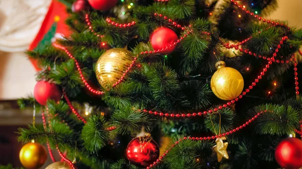 Natal closeup fundo com bugigangas coloridas e guirlandas penduradas na árvore de Natal — Fotografia de Stock