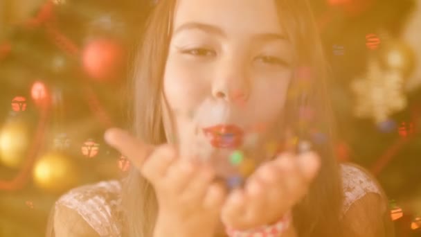 Closeup 4k πλάνα του όμορφο κορίτσι φυσάει πολύχρωμα κομφετί από χέρια και χαμογελαστός στην κάμερα — Αρχείο Βίντεο