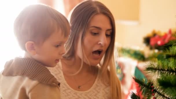 Genç Anne ve küçük oğlunu Noel ağacı için cam baubles bıraktıktan sonra korkmuş görüntülerini closeup 4k — Stok video