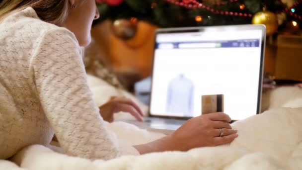4 k záběry z mladé ženy pomocí přenosného počítače kupovat dárky a dárky na Vánoce v online obchodě
