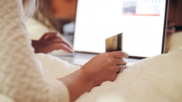 Closeup 4k vídeo de mulher jovem usando laptop e segurando cartão de crédito na mão. Conceito de compras on-line e compras na internet — Vídeo de Stock