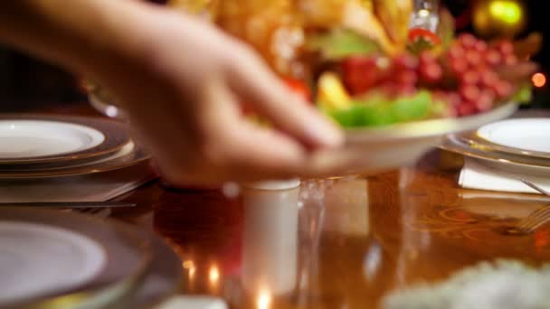 Primer plano 4k metraje de la mujer joven poniendo plato con pollo al horno en la mesa de la cena servido para Navidad — Vídeo de stock