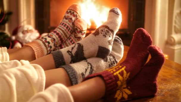 Closeup 4k video of family with child wearing warm wool socks lying by the fireplace on Christmas eve — Stock Video
