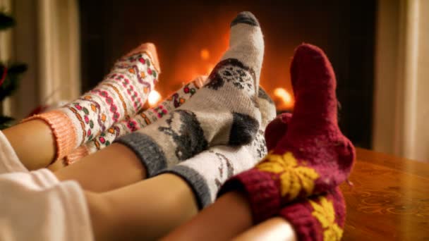 Closeup 4k video of family wearing warm knitted socks resting by the fireplace at living room — Stock Video