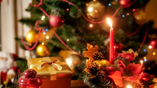 特写4k 镜头的蜡烛和传统的花圈反对发光的圣诞灯夜间。冬季庆典和节假日的完美背景 — 图库视频影像