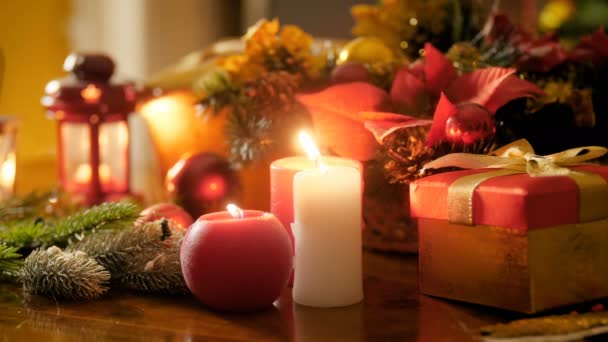 Крупним планом 4 к кадри з запалених свічок і ліхтарі проти традиційних вінок і різдвяні подарунки та подарунки. Відмінний фон для зимових свят і канікул — стокове відео