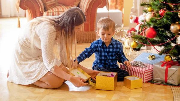 Neşeli küçük çocuk Noel hediyeleri sabah açar. — Stok fotoğraf