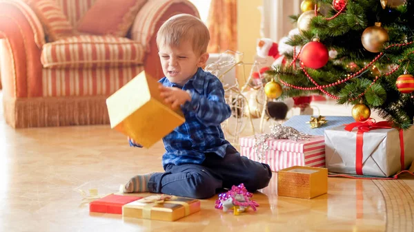 Porträt eines kleinen Jungen ärgert sich über unerwünschtes Weihnachtsgeschenk — Stockfoto