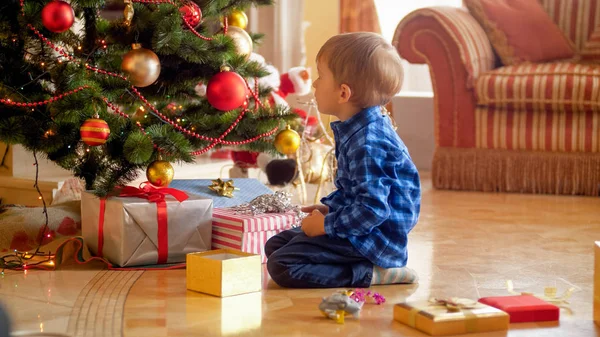 Pequeño niño mirando el árbol de navidad por la mañana — Foto de Stock