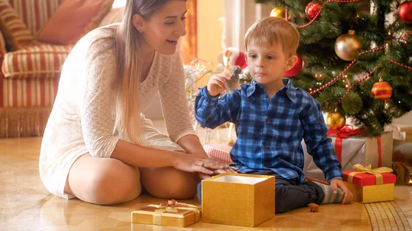Lilla barn pojke tittar på leksak han fick i nuvarande box för jul — Stockfoto