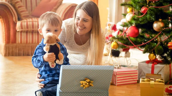 Feliz niño tomando juguete de peluche de la caja de regalo de Navidad —  Fotos de Stock