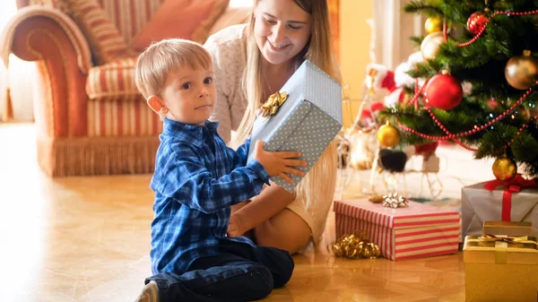 Возбужденный улыбающийся мальчик держит большую коробку с рождественским подарком — стоковое фото