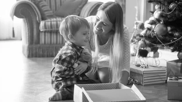 Portrait noir et blanc de joyeux petit garçon embrassant jouet en peluche qu'il a reçu pour CHristmas — Photo