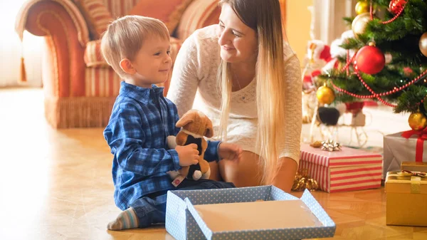Тонированный портрет улыбающегося мальчика с игрушкой, которую он получил на Рождество от Санты — стоковое фото