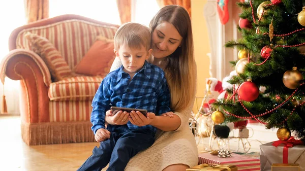 크리스마스 아침에 전화에 비디오를 아이와 어머니의 초상화 — 스톡 사진