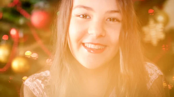 Portrait of beautful smiling girl posing against decroated Christmas tree — Stock Photo, Image