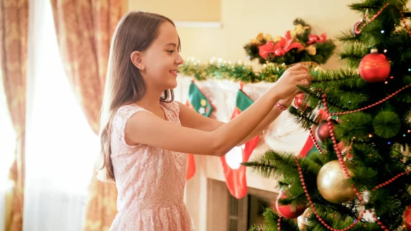 Retrato de hermosa adolescente sonriente decorando el árbol de Navidad con adornos — Foto de Stock