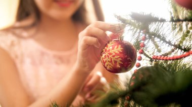 Genç kadının kırmızı dekoratif babubles Noel ağacı dalına koyarak portre resim