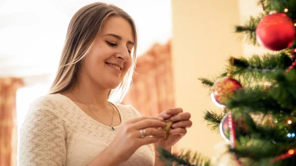 Güzel gülümseyen genç kadın ayakta portresi süslenmiş Noel ağacı — Stok fotoğraf