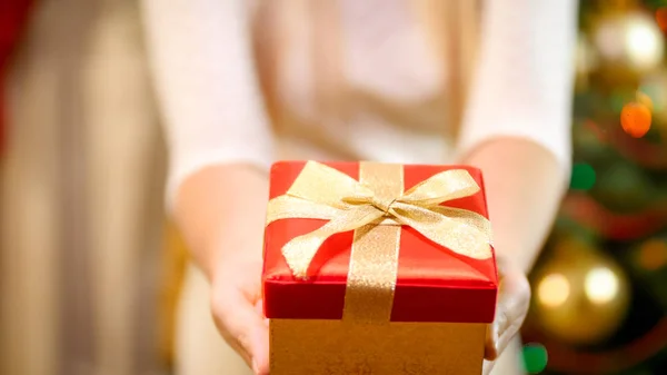 Close-up beeld van vrouw in jurk tonen in de camera aanwezig Christmas box — Stockfoto