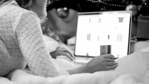 Black and white image of young woman ordering Christmas gifts online — Stock Photo, Image