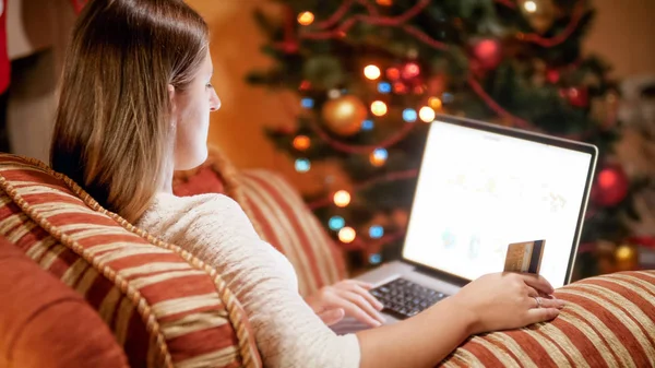 Krásná mladá žena sedí na Štědrý večer v obýváku a dělat online objednávky — Stock fotografie