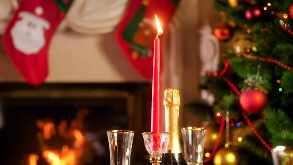 CLOseup immagine di bruciare candela festiva contro il camino e decorato albero di Natale — Foto Stock