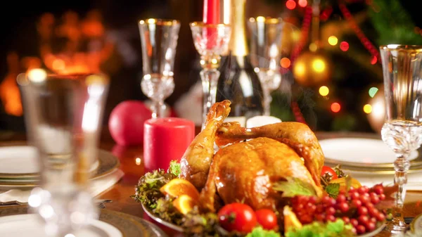 Closeup photo of hot baked chicken on festive table against Christmas tree and fireplace — Stock Photo, Image