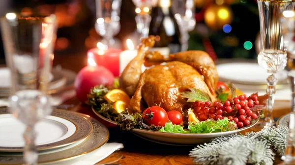 Closeup image of baked turkey on family festive dinner table against burning fireplace