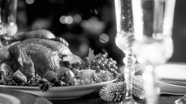 焼きチキンとお祭りダイニング テーブルの上のシャンパン グラスの黒と白のイメージ — ストック写真