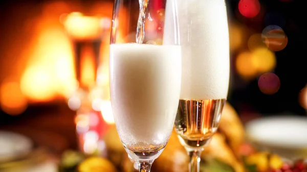 Zbliżenie obraz nalewanie szampana w okularach na romantyczny obiad Bożego Narodzenia — Zdjęcie stockowe