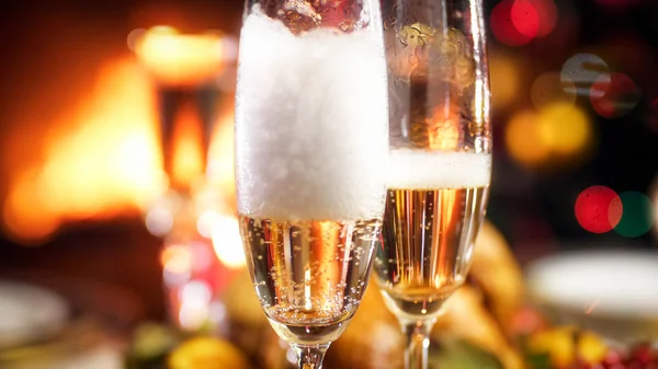 Imagen de primer plano de espuma de champán asentándose en dos copas en la cena de Navidad —  Fotos de Stock