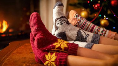 Örme Çorap Noel arifesinde yanan şömine tarafından rahatlatıcı aile portre resim