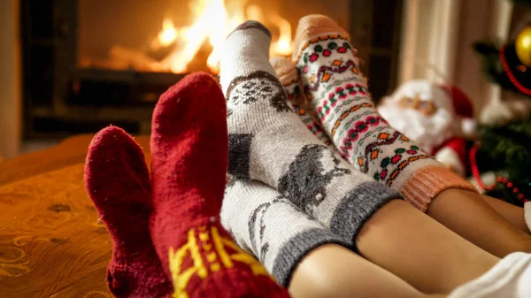 Фото крупным планом женских ног в теплых шерстяных носках, согревающих у камина дома — стоковое фото