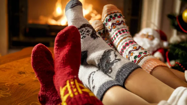 Photo rapprochée de la famille couchée à la cheminée dans la maison et les pieds chauffants — Photo